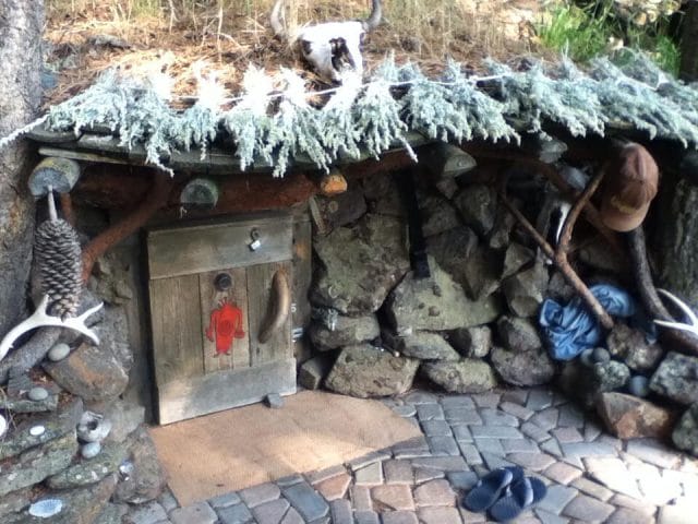 a stone building with a roof and a door with a couple of cats on it