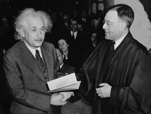 Albert Einstein shaking another man's hand