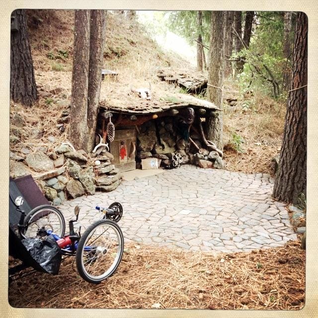 a stone path with a hut and trees