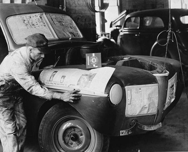 a person reading a newspaper on a car