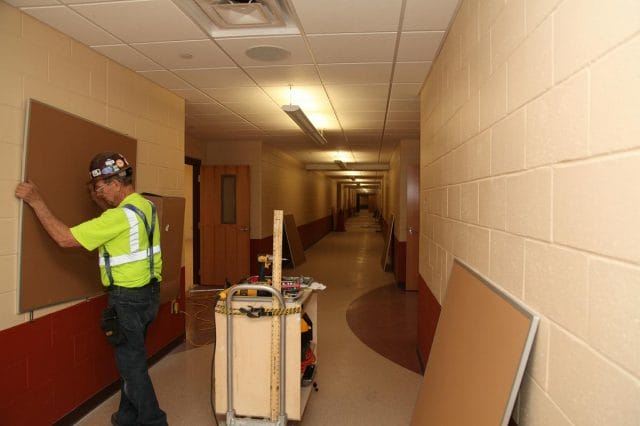 a man in a safety vest standing in a hallway