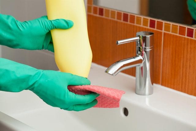 a person's hand holding a towel over a sink