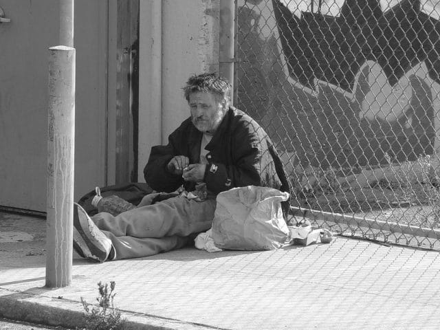 Otzi sitting on the sidewalk