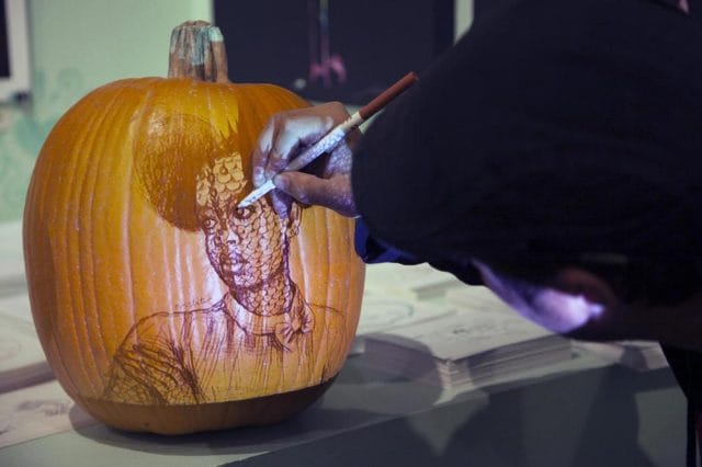 a person carving a pumpkin
