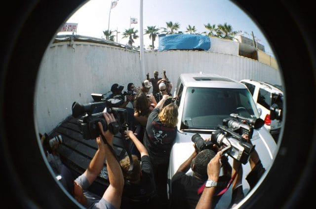 a group of people taking pictures of a car