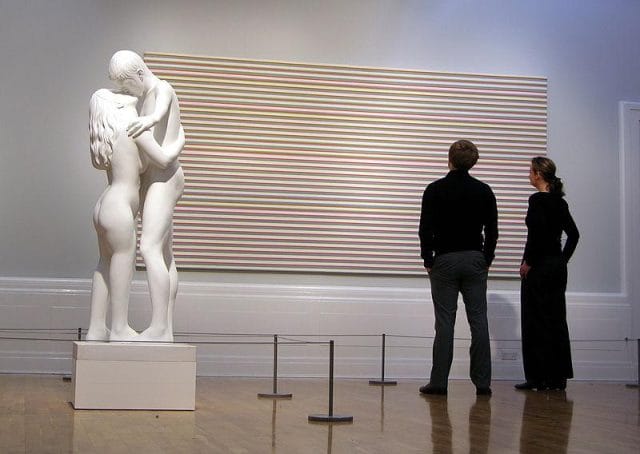 a man and a woman looking at a large sculpture