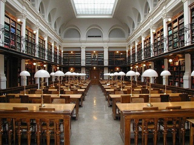 a large library with tables and chairs