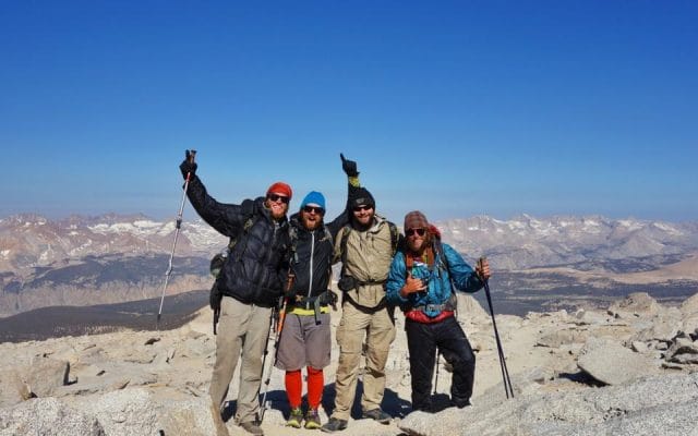 a group of people posing for a photo on a mountain