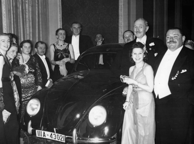 a group of people standing around a car