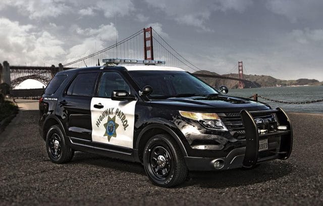 a black car parked in front of a bridge