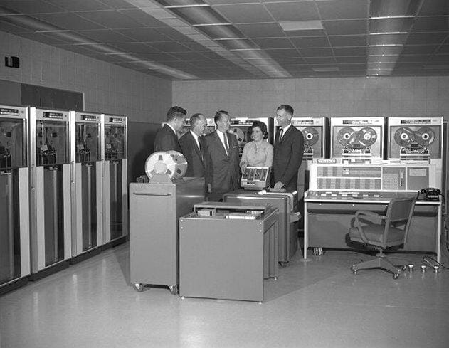 a group of people standing in a room with machines