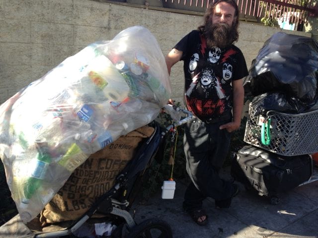 a man pushing a cart full of garbage
