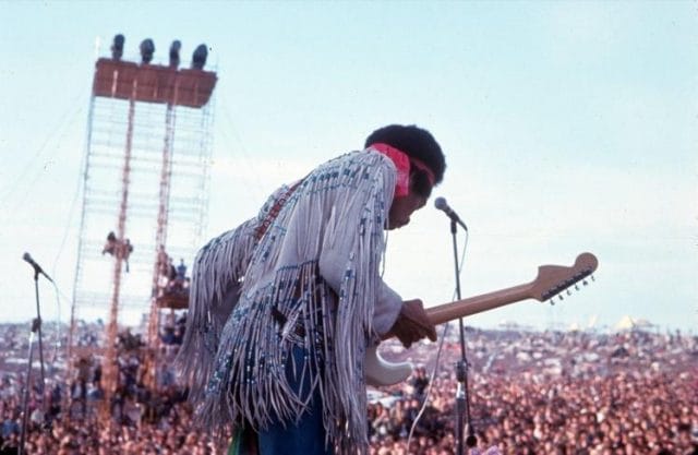 a man playing guitar in front of a large crowd