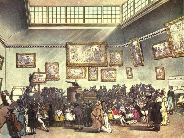 a group of people in a room with paintings on the wall