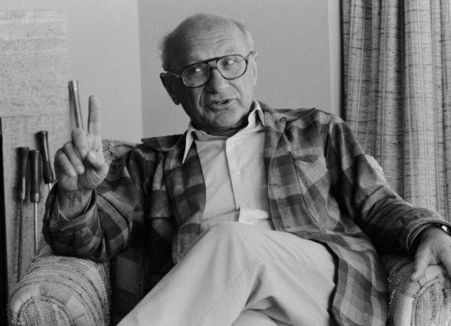 Milton Friedman sitting in a chair