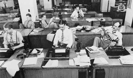 a group of people sitting at desks with headsets on