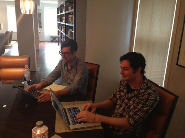a man and a woman using laptops