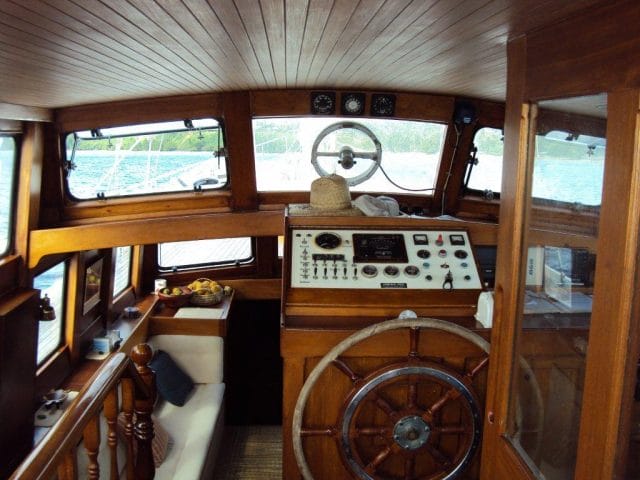 a wooden boat with a steering wheel