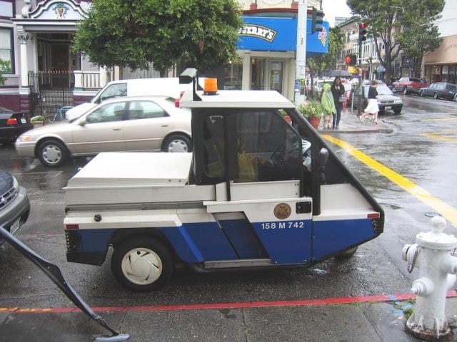 a small white boat is parked on the side of a street