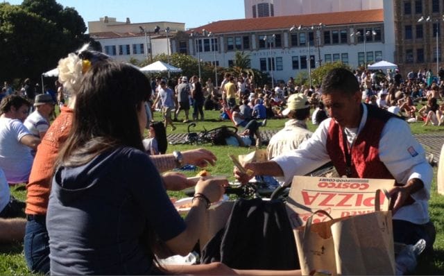 a man and woman sitting on the ground with boxes in front of them