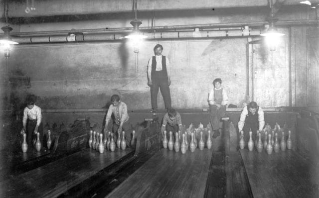 a group of people standing next to a table with bottles on it