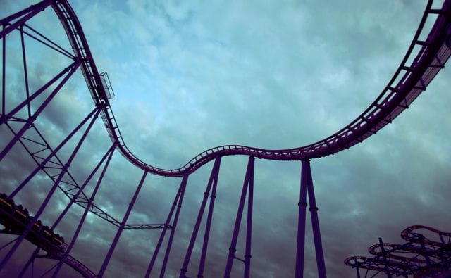 a roller coaster with a cloudy sky