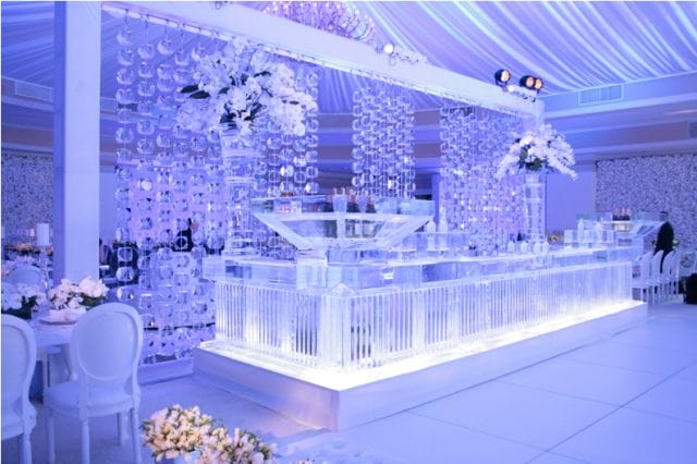 a room with a large white table and chairs and a large chandelier with flowers on it