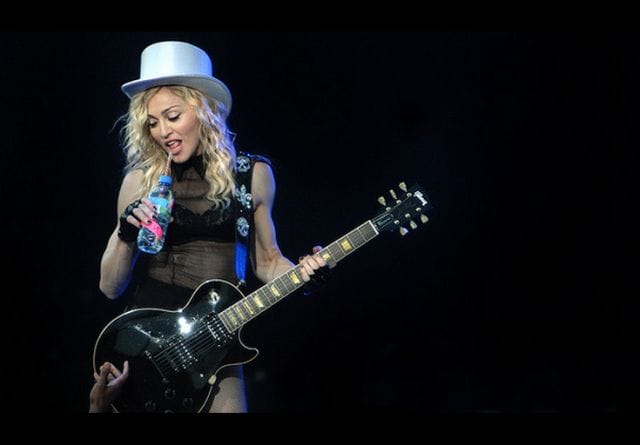 Madonna playing a guitar