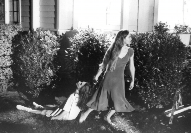 a person kneeling down next to a person lying on the ground