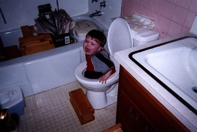 a kid sitting on a toilet