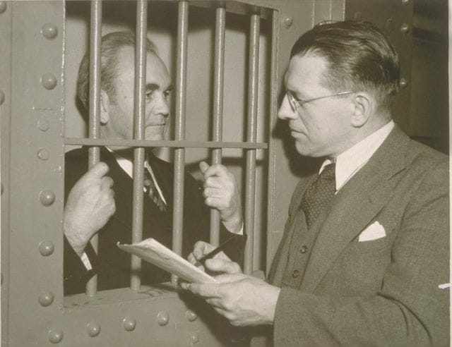 Thomas Mooney in a suit looking at a paper