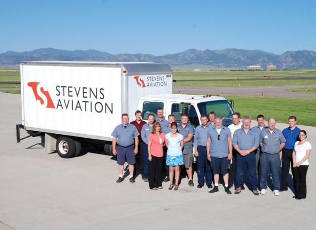 a group of people posing for a photo next to a white truck