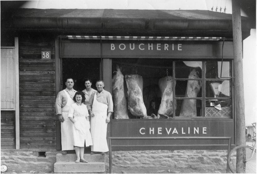 a group of people standing in front of a building with a sign