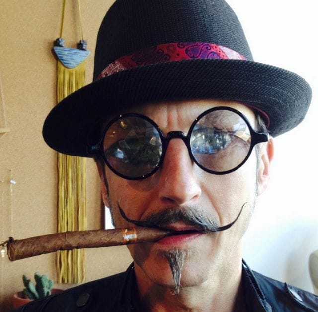 a man with a cigar in his mouth and a hat