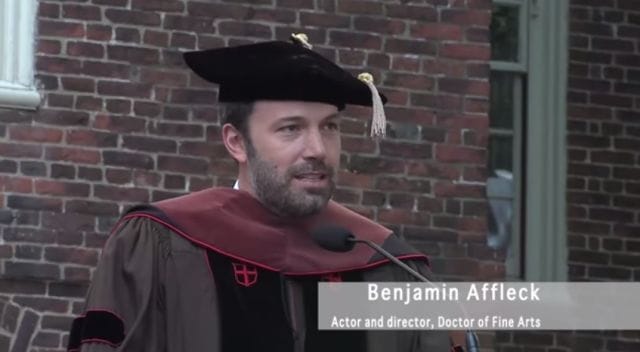 Ben Affleck wearing a hat and standing in front of a microphone