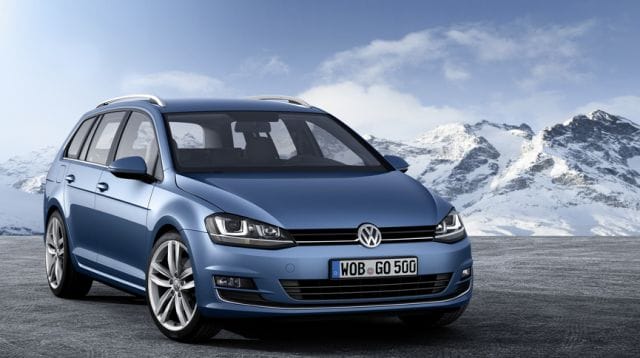a car parked on a road with snowy mountains in the background