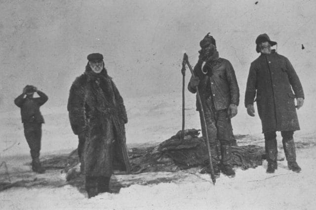 a group of men walking on a snowy hill