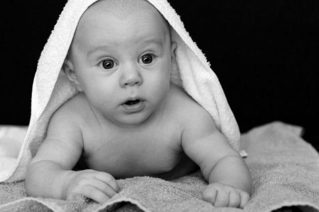 a baby lying on a blanket