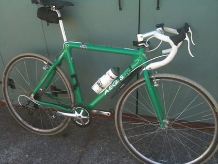 a green bicycle with a white bottle on the seat