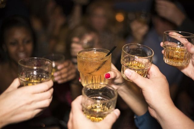 a group of people holding glasses with liquid in them