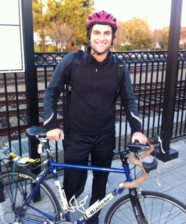 a person wearing a helmet and standing next to a bicycle