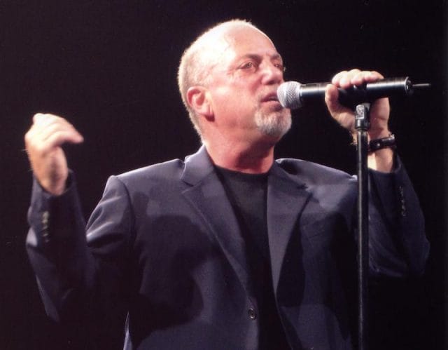 Billy Joel holding a microphone