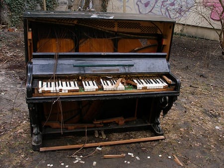 a piano outside with a stick in the front