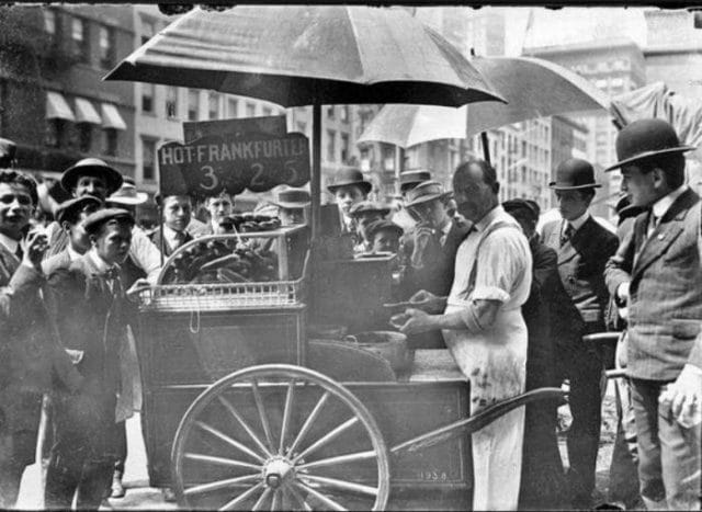 a group of people standing around a cart with a person in it