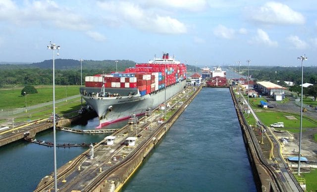 a large ship on a river with Panama Canal in the background