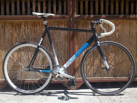 a bicycle parked in front of a wooden fence