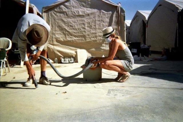 a man using a hose to water a pipe