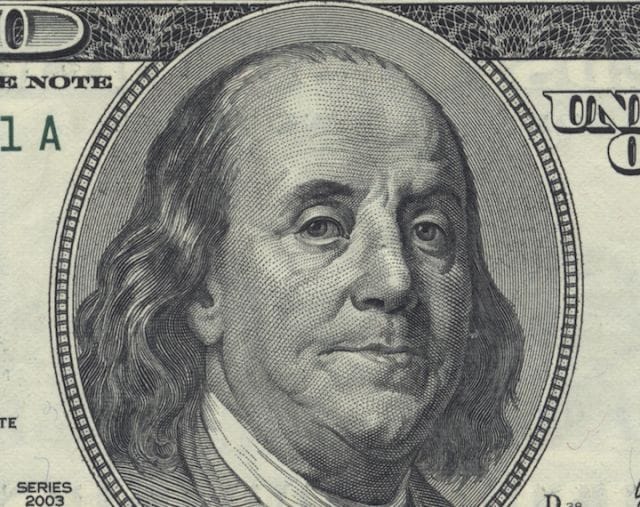 a close-up of Benjamin Franklin's face on a dollar bill