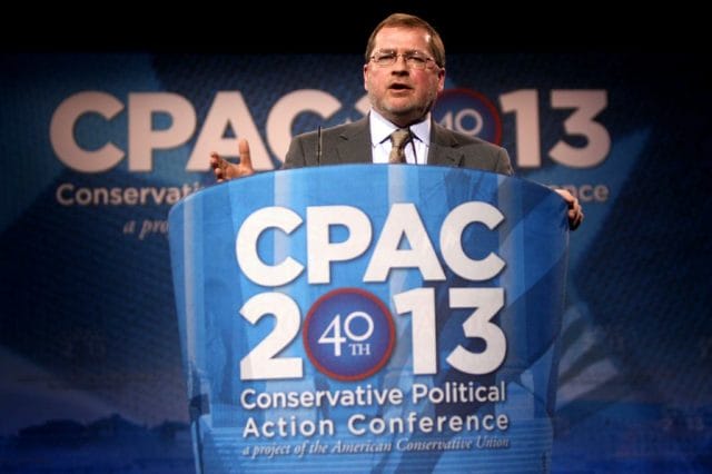 Grover Norquist holding a sign