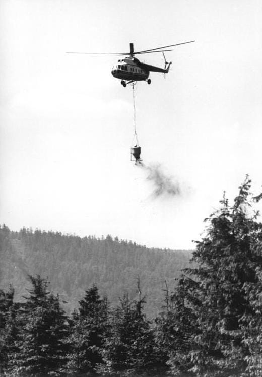 a helicopter flying over trees